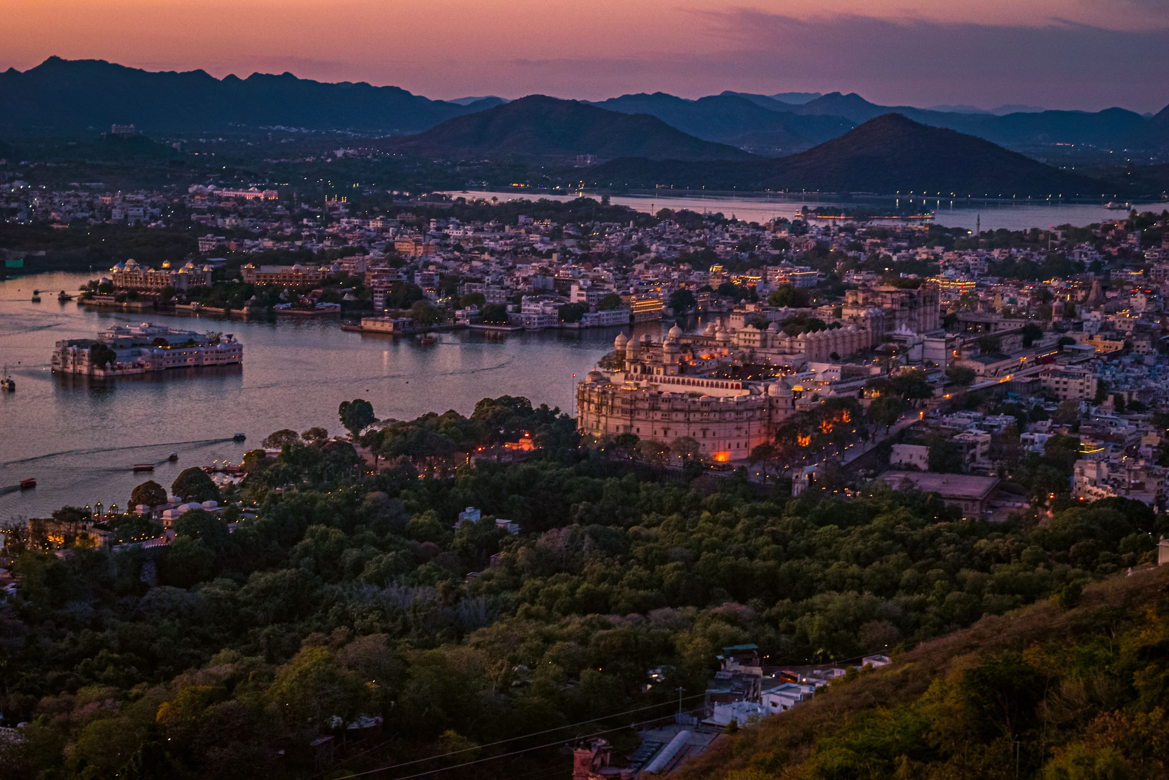 Udaipur at dusk from the Aravalli hills, with the lakes and the old city lit up